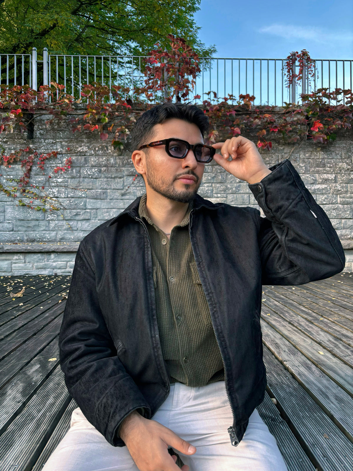 Person wearing EYENEED eyewear in a dark jacket